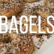 cooked bagels on a cookie sheet with the word BAGELS written