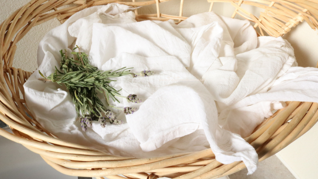wicker basket filled with flour sack towels and fresh cut french lavender from the herb garden