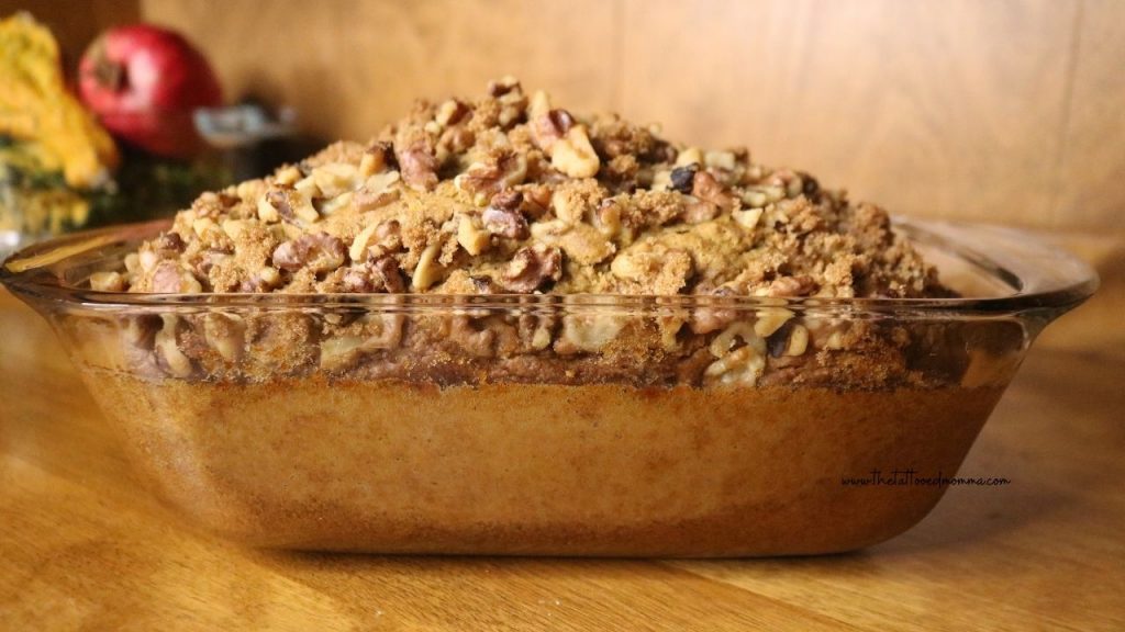 sourdough pumpkin banana bread in a glass loaf pan topped with walnuts and brown sugar