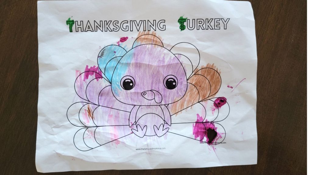 thanksgiving turkey coloring page that is already colored in with pink, blue, and brown crayon. 
